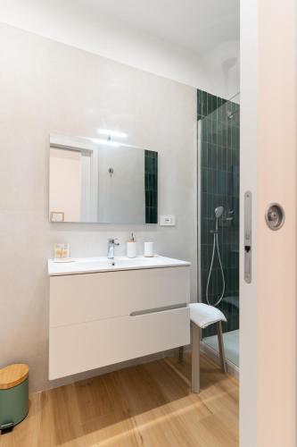 a white bathroom with a sink and a shower at Il Giardinetto Guest House in Civitavecchia