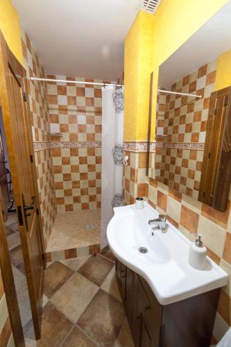 a bathroom with a sink and a shower at Casa rural BUSEO in Chera
