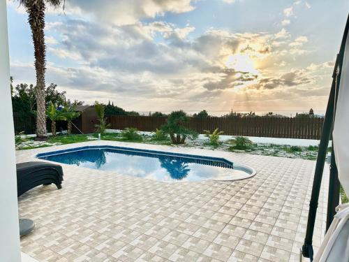 a swimming pool in a backyard with a palm tree at Casa Elea in Kouklia