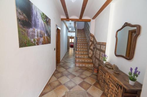 a hallway with a staircase and a mirror on the wall at Casa rural BUSEO in Chera