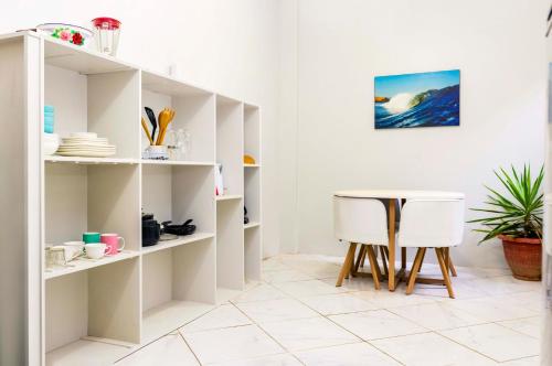 ein Esszimmer mit weißen Regalen und einem Tisch in der Unterkunft Tides Lobitos in Lobitos