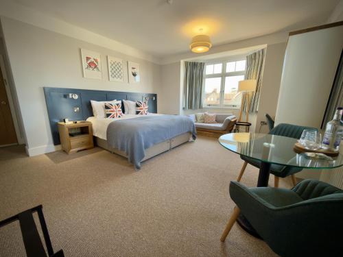 a bedroom with a bed and a table and chairs at The Ship Inn in Weybourne