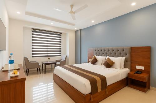una camera da letto con un letto, un tavolo e delle sedie di OPO VERTU Premium Delhi Aerocity a Nuova Delhi