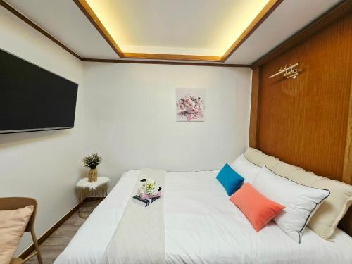 a small room with a bed and a flat screen tv at MIIN Stay02 in Seoul