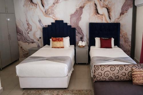 En eller flere senge i et værelse på MATAT GARDENS