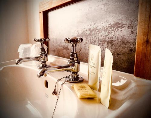 a bathroom sink with a faucet and a mirror at Ocean View Bar & Rooms in Laide