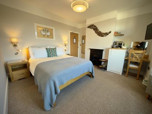 a bedroom with a bed and a fireplace in it at The Ship Inn in Weybourne