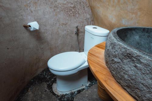 a bathroom with a toilet and a bath tub at The Kul Kul Farm in Bringkit
