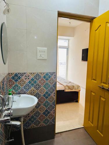 a bathroom with a sink and a room with a bed at Pitambar in Varanasi
