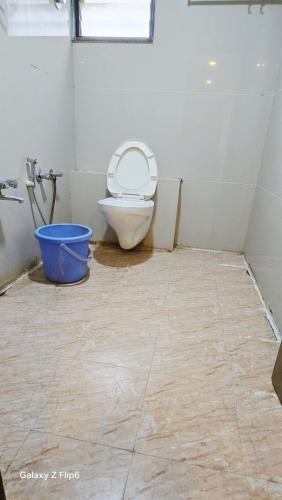 a bathroom with a toilet with a bucket in it at Hotel ShivInn in Gandhinagar