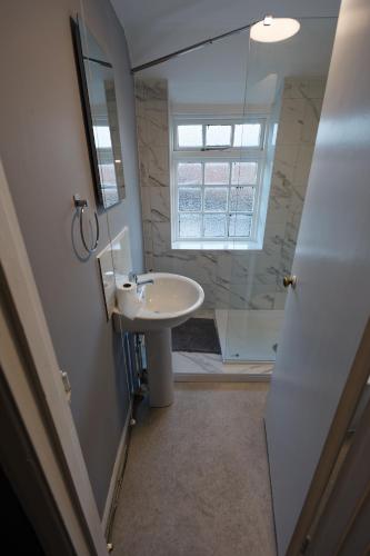 a bathroom with a sink and a window at Monk and Tipster in Towcester