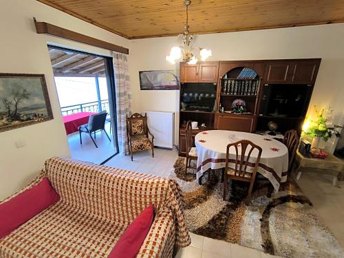 a living room with a table and a couch at xanthi's sea front villas in Flámbouras