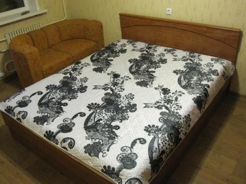 a bed with a black and white comforter on it at Apartment Kropotkina 11a in Voronezh