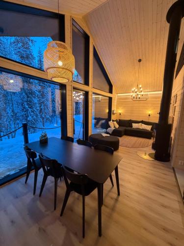 een eetkamer met een tafel en stoelen en een woonkamer bij Villa Syli in Äkäslompolo