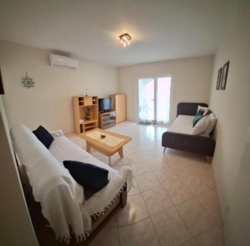 a living room with a couch and a table at Apartments Villa Granda Tolic in Biograd na Moru