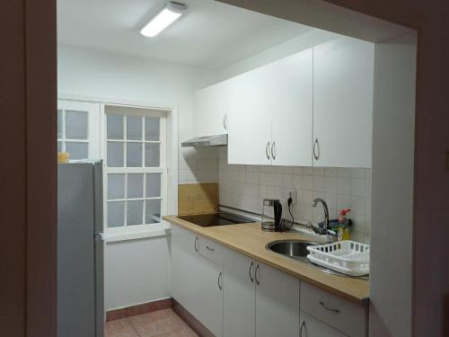 a kitchen with white cabinets and a sink at SEASTAR nº38 in Horta