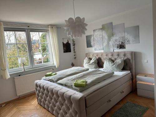 a bedroom with a large bed in a room with windows at FeWo Am Reinhardsberg in Friedrichroda
