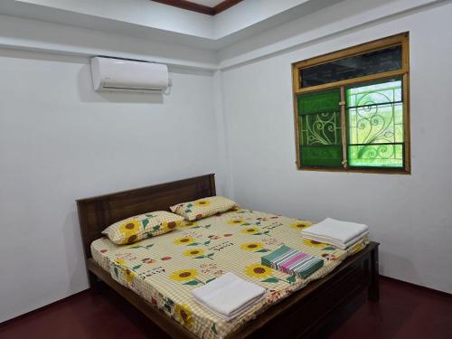 a small bedroom with a bed with a window at Annai Agham in Kankesanturai