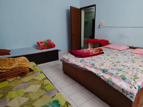 una camera da letto con due letti e uno specchio di Swaroop Ashray Homestay a Siliguri