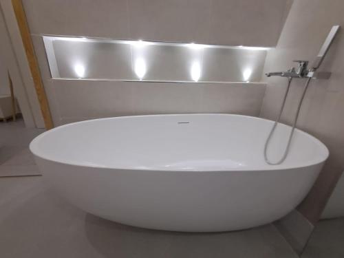 eine weiße Badewanne mit Wasserhahn im Badezimmer in der Unterkunft Keur Kibibi in Somone