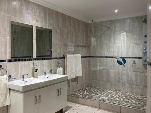 een badkamer met een wastafel en een douche bij St Helena Bay Hotel in St Helena Bay