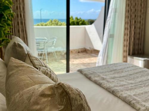 een slaapkamer met een bed met uitzicht op de oceaan bij St Helena Bay Hotel in St Helena Bay