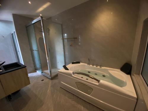a large bathroom with a tub and a shower at Hotel Saphir Group in Douala