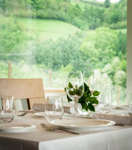 a table with wine glasses on it with a window at Palacio de Yrisarri by IrriSarri Land in Igantzi