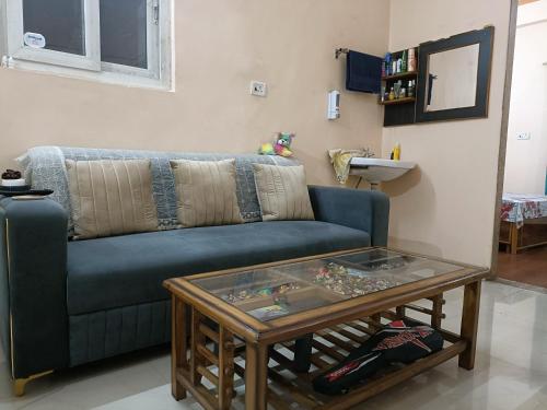 een woonkamer met een blauwe bank en een tafel bij Shakti HomeStay - Kashi Dham in Varanasi