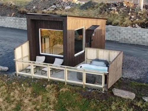 a tiny house sitting on the side of the road at Unik og moderne microhytte med utsikt mot havet 40 A Otterlei Resort in Longva