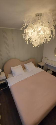 a bedroom with a large white bed and a chandelier at Purjemaja in Otepää