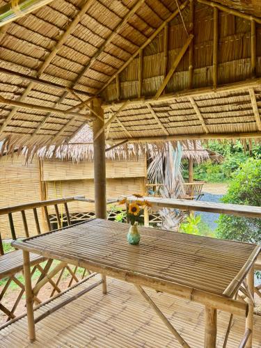 a wooden table with a vase sitting on top of it at Bunga Hut Koh Lanta in Ko Lanta