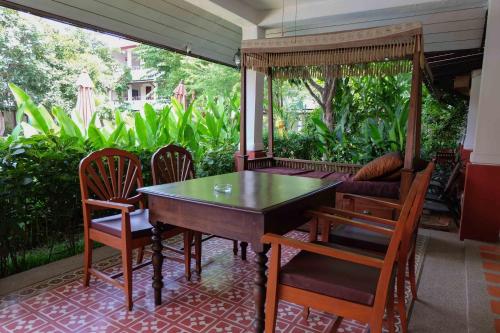a table and chairs on a screened in porch at Karinthip Village in Chiang Mai