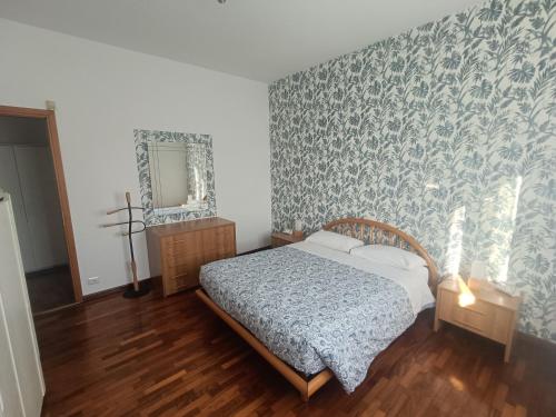 een slaapkamer met een bed, een ladekast en een spiegel bij B&B Il Melograno in Lomazzo