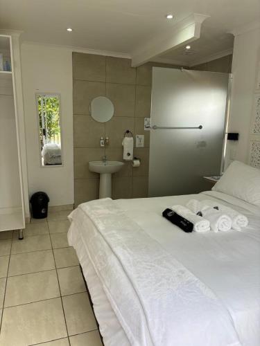 a bedroom with a white bed and a sink at Seven on Cooper in East London