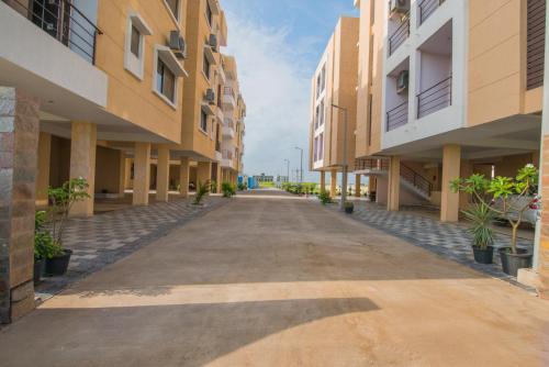 an empty street between two buildings at Budget Inn Service Apartments - Tiger Plaza in Vengni