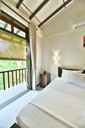a bedroom with a bed and a balcony at Mansion view in Unawatuna