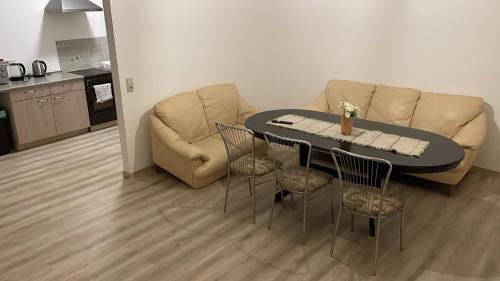een woonkamer met een bank, een tafel en stoelen bij Wohnung am Bahnhof in Schmalkalden