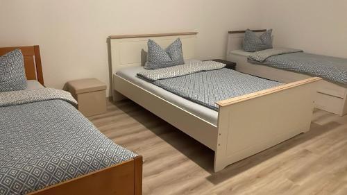2 aparte bedden in een kamer met houten vloeren bij Wohnung am Bahnhof in Schmalkalden