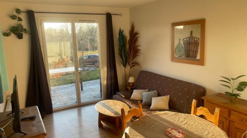 een woonkamer met een bed, een bank en een raam bij Gîte du bosquet in Égletons