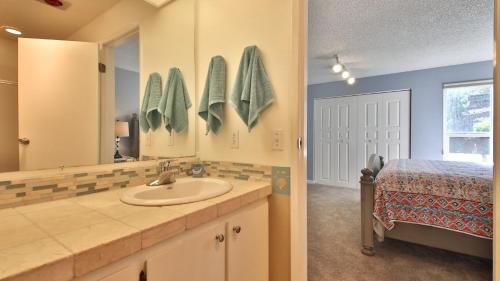 a bathroom with a sink and a mirror and a bed at Beachfront Condo - Mutiny Bay by AvantStay Views in Freeland