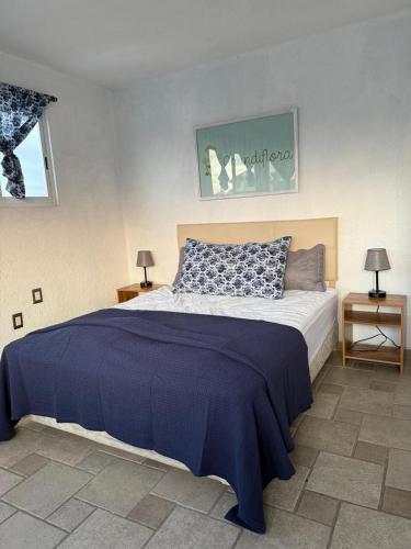 a bedroom with a large bed with a blue blanket at Casa El nido de las flores in Oaxtepec