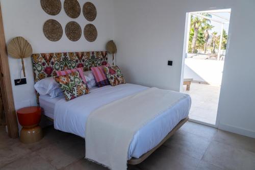 a bedroom with a white bed with pillows at Hostal Playa Pitaya in Torre del Mar