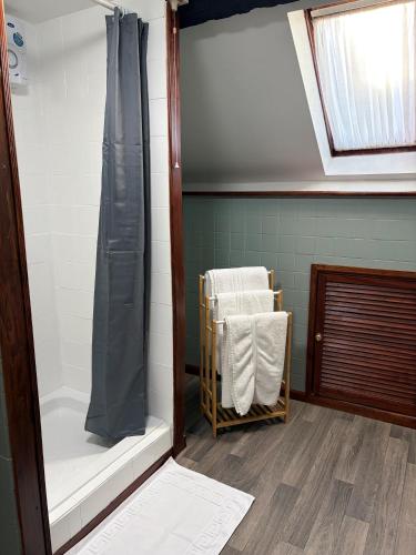 a bathroom with a shower and a chair in it at The Black Swan Inn in Leominster