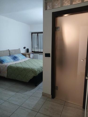a bedroom with a bed and a sliding door at Sleep & Relax in Nizza Monferrato