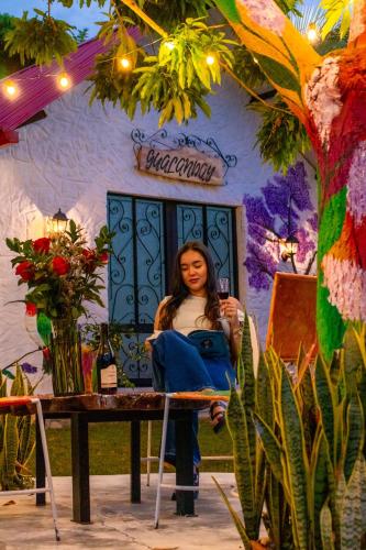 a woman sitting at a table in front of a building at Cabañas Villa del Prado in Gigante