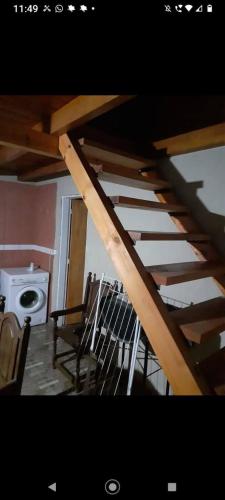 a wooden staircase in a room with a washing machine at Casita Walden in Cosquín