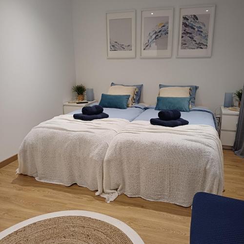 a bedroom with a large bed with blue pillows at Casa Terra das Vinhas in Esposende