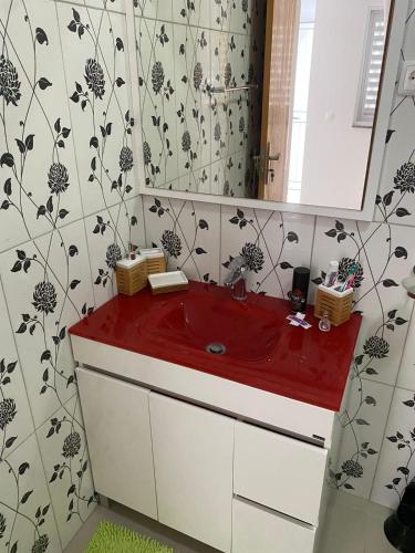 a bathroom with a red sink and a mirror at Casa Melissa in Ponta do Sol