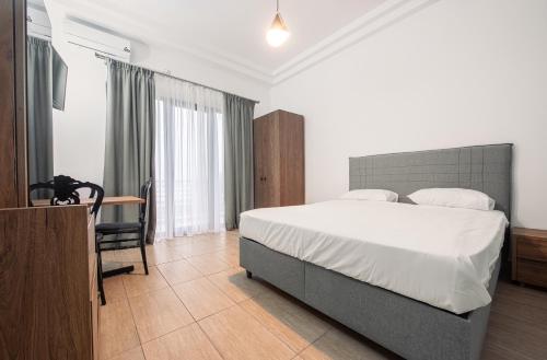 a bedroom with a bed and a desk and a chair at Pensiunea EDY in Mangalia